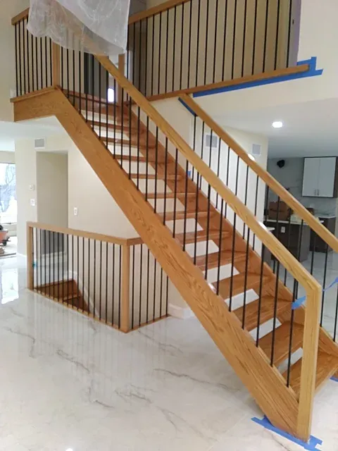 Custom staircase with wood handrail and metal balusters